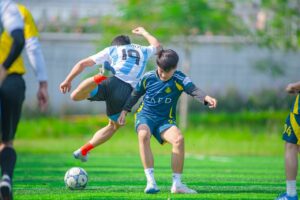 Intense football action captured on a sunny day in Hà Nội, Vietnam.